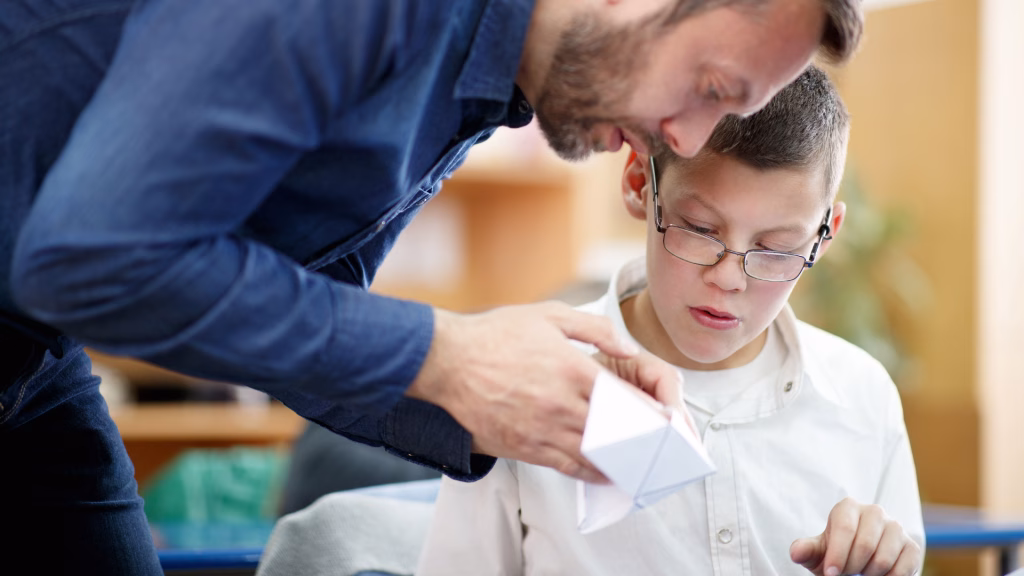 Child with glasses working one-on-one with a psychologist for their special education evaluation.